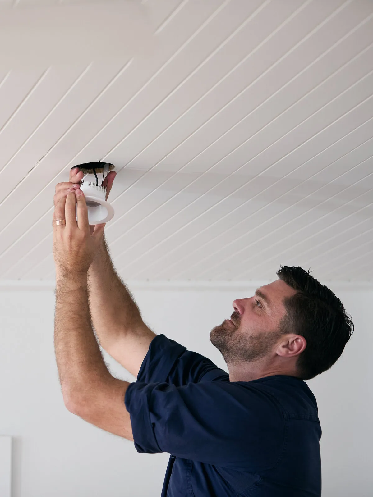 Kitson electrician fitting a downlight in a Newcastle home